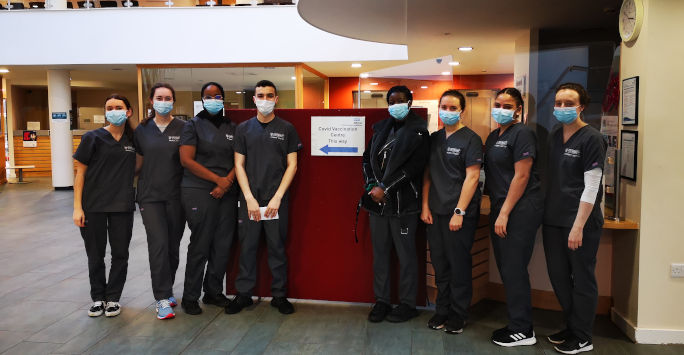 Line of students in scrubs wearing masks