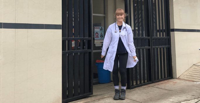 Student doctor in doctor coat outside clinic