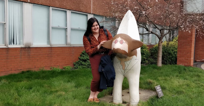 A student poses with a lamb-banana sculpture
