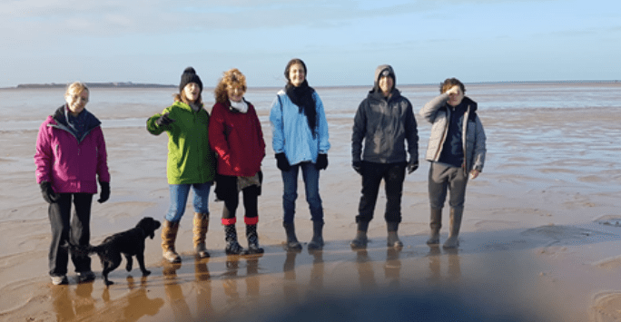 photo of a group of people in winter coats on the beach
