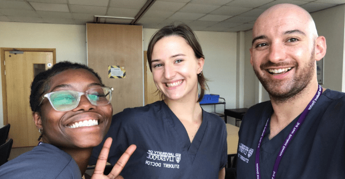 three student doctors dressed in grey scrubs
