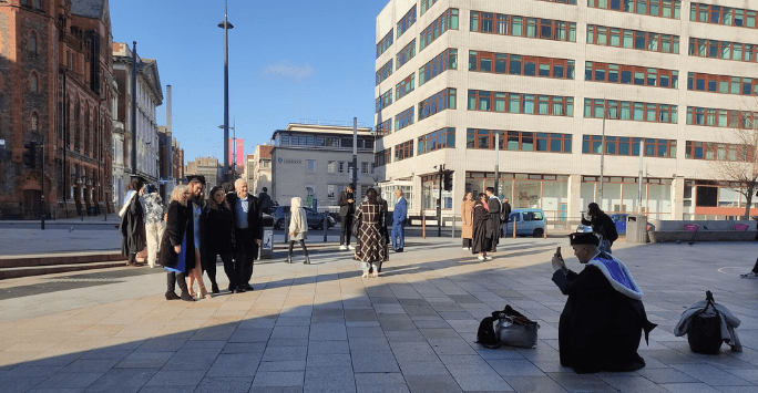 graduates take photos on University Square
