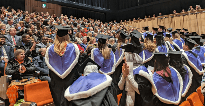 graduates clap their loved ones