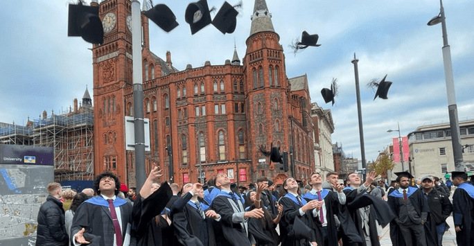 graduates throw their caps into the air