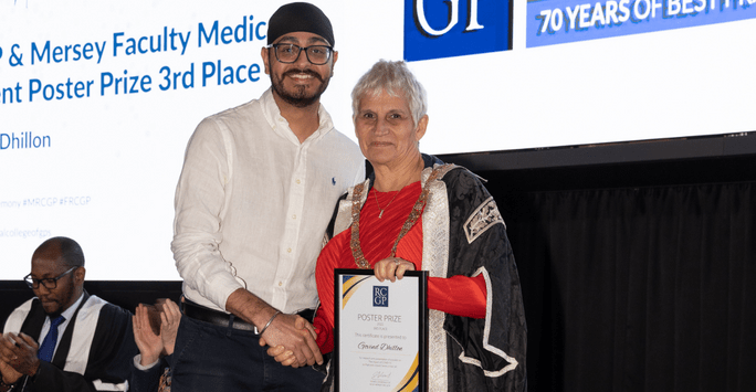 student receives certificate in front of big screen