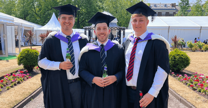 three graduates in caps and gowns