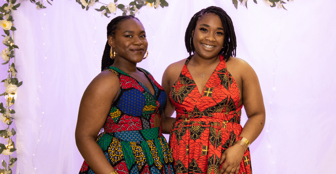 two women in brightly coloured dresses at culture ball