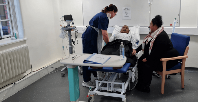 a student doctor works with a simulated patient and relative actors in a clinical scenario