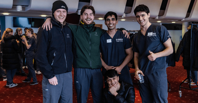 a group of student doctors in scrubs pose for a photo opp