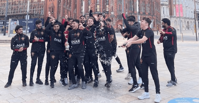 students in matching tracksuits spray champagne as they celebrate
