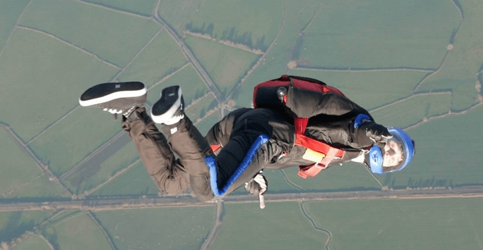 man skydiving and signalling to communicate