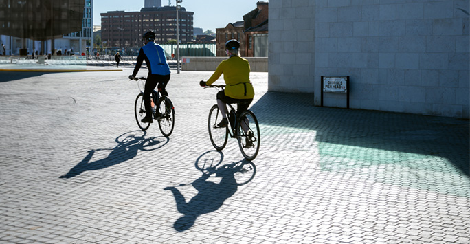 Two cyclists in sunny Liverpool docks