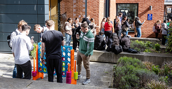 Students playing giant connect 4 in the garden