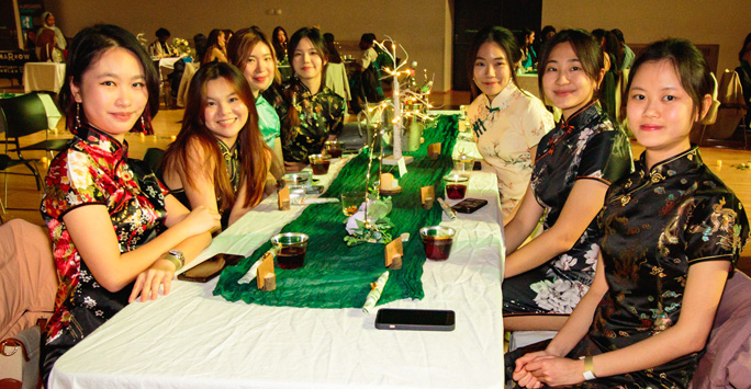 International students sit around table to enjoy multicultural buffet