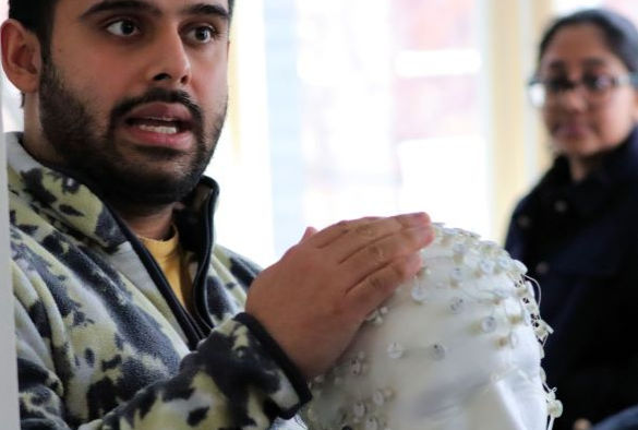 PhD student holds EEG equipment