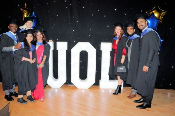 Health Data Science students stand in front of a light up UOL sign