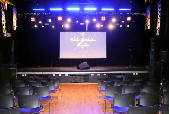 Rows of chairs in front of a screen in Mountford Hall