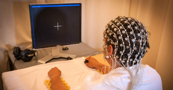 A particpant in a pschology experiment wearing a headset and using a computer A particpant in a pschology experiment wearing a headset and using a computer