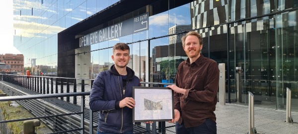 Callum Hewitt presenting his drawing to Open Eye Gallery