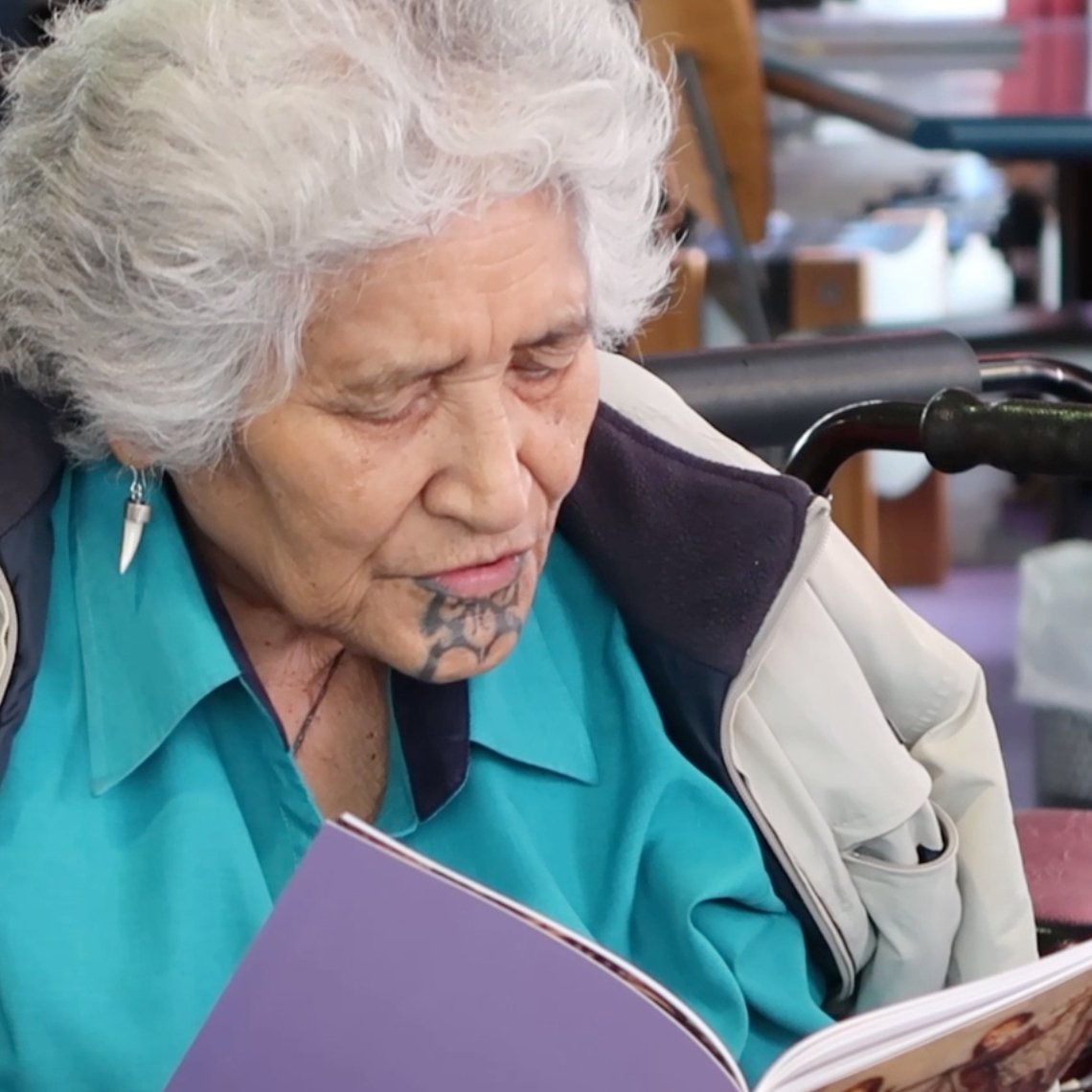 Woman with chin tattoo reading