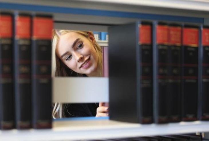 A student looks through the shelves in a campus library