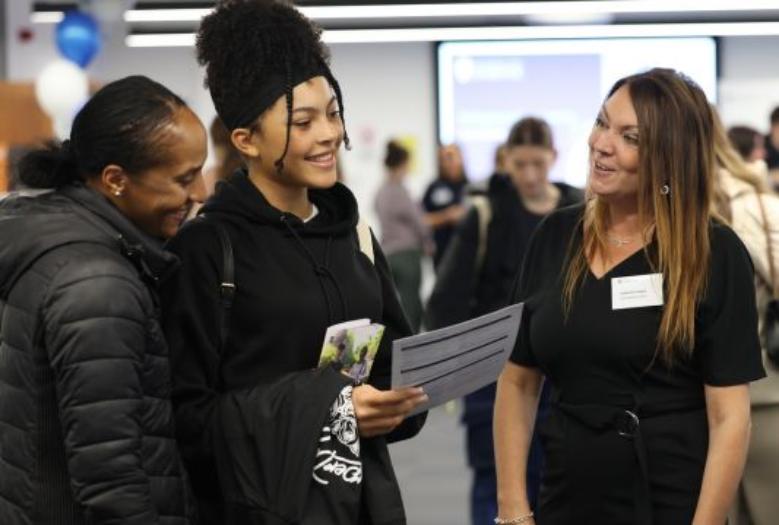 A student chats with staff at an event