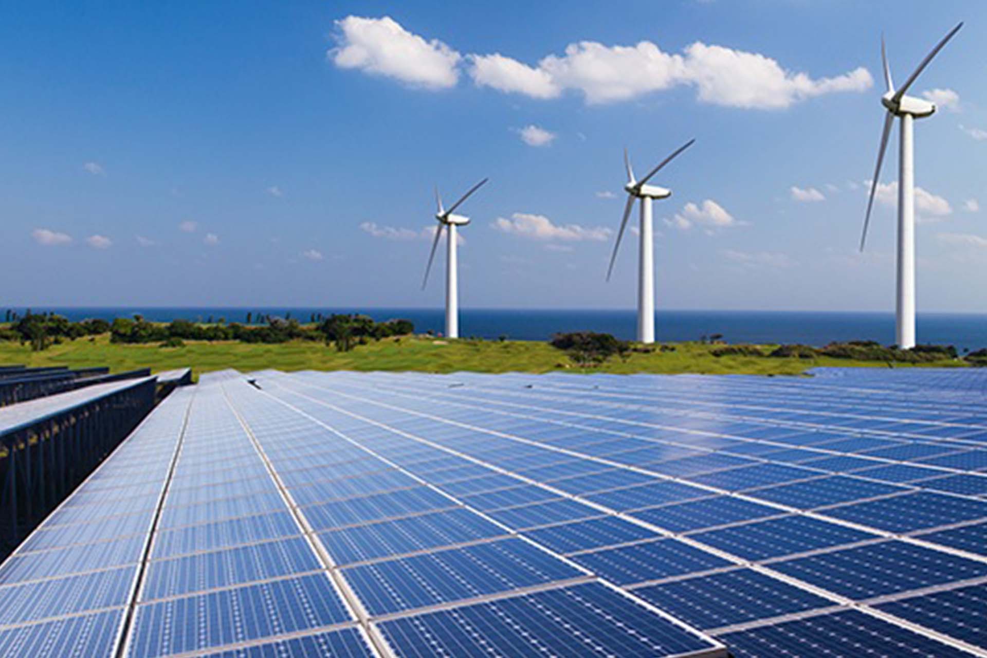 A landscape featuring solar panels and wind turbines