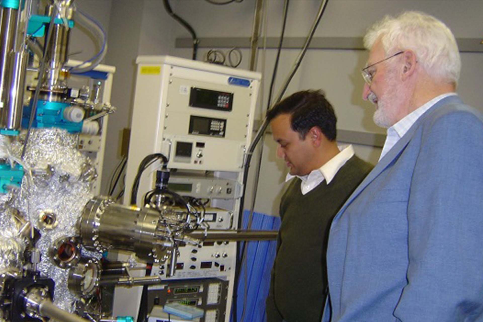 Hem Raj Sharma standing near a piece of equipment in a lab