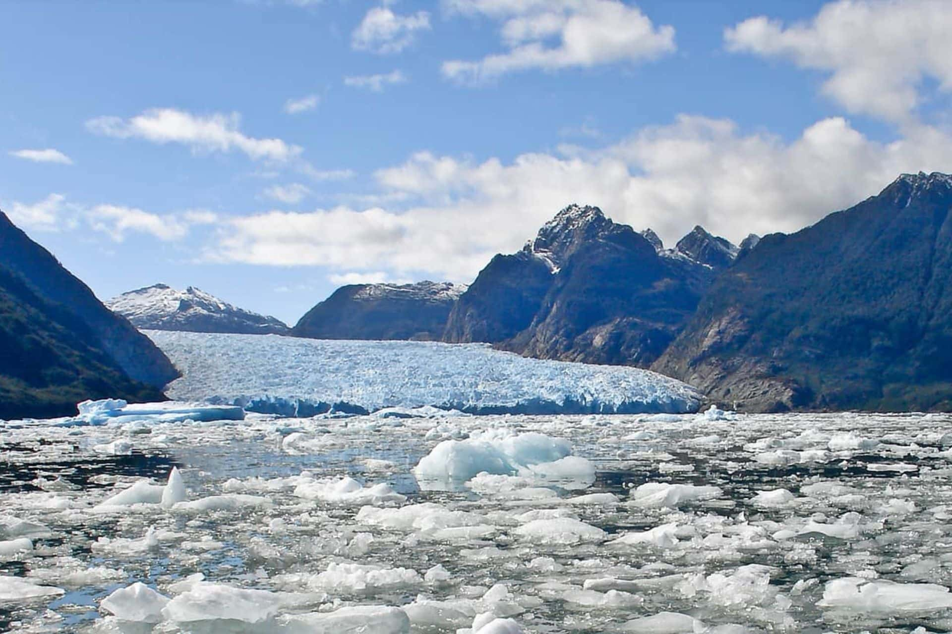 A icy landscape depicting mountains and large chunks of ice floating in the sea