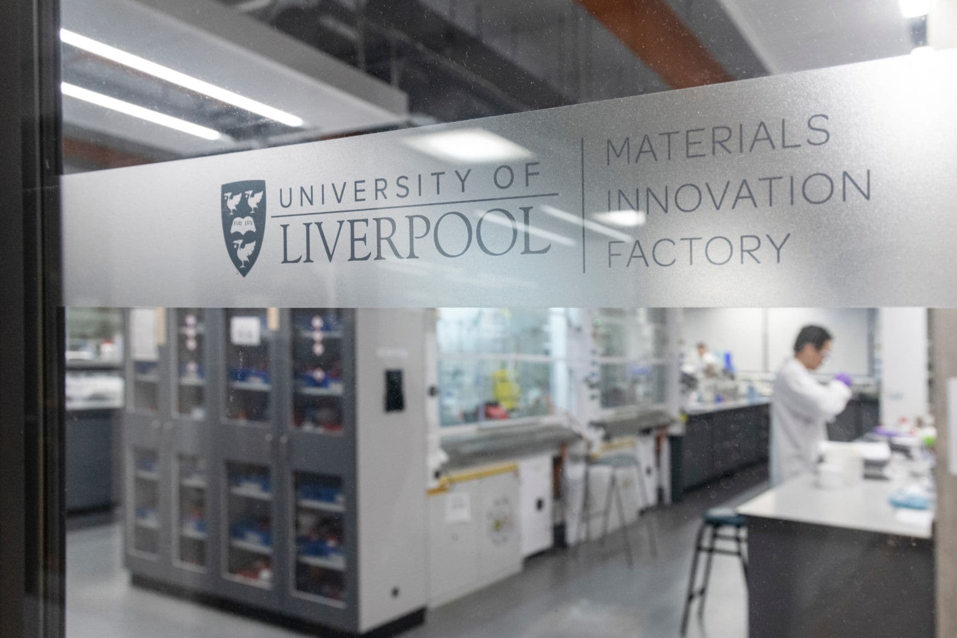 A through-the-window view of a scientist working in one of the labs in the Materials Innovation Factory
