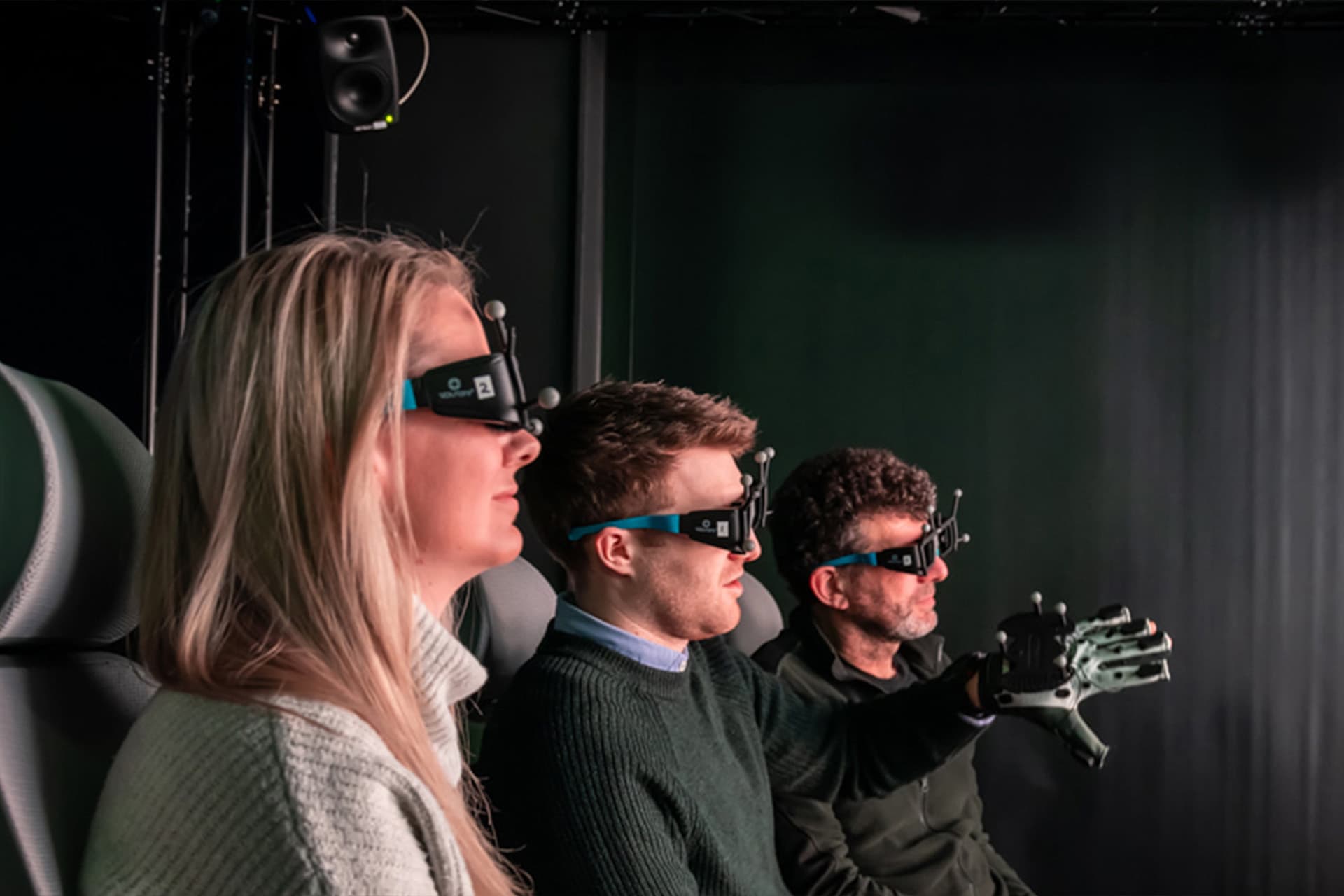 Three people using virtual reality viusalising technology at the VEC