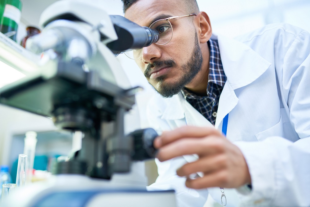 A scientist looks through a molecular microscope