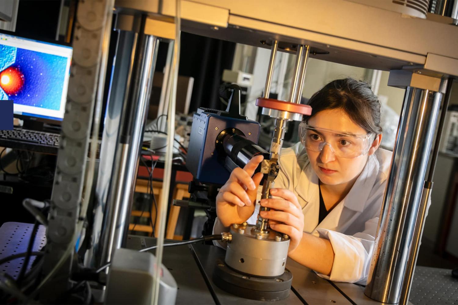 A researcher using piece of machinery in a lab