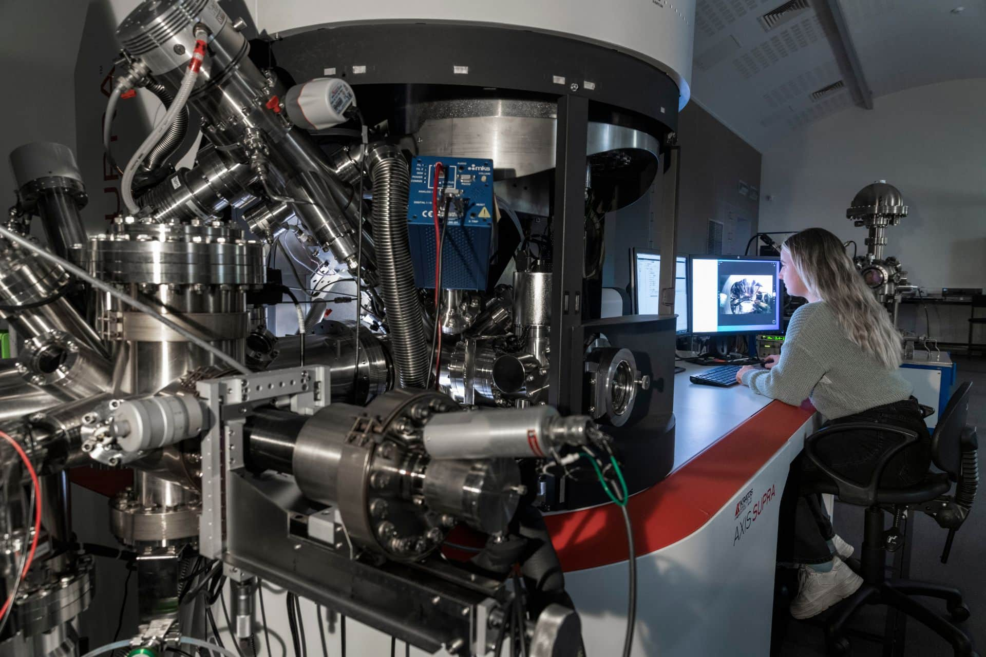 A student working on a computer next to a large lab device