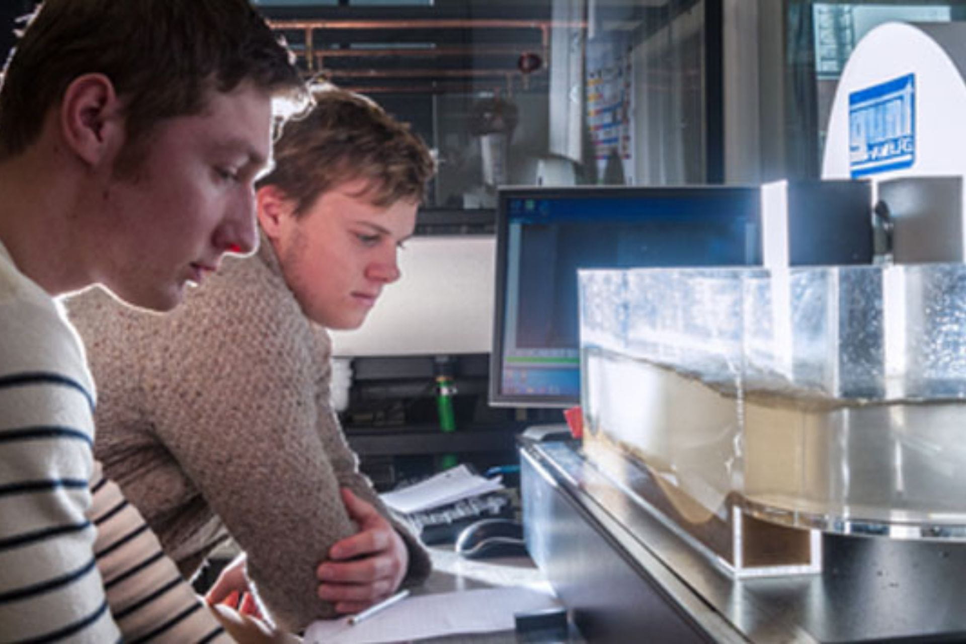 Two students looking at a water filtration system