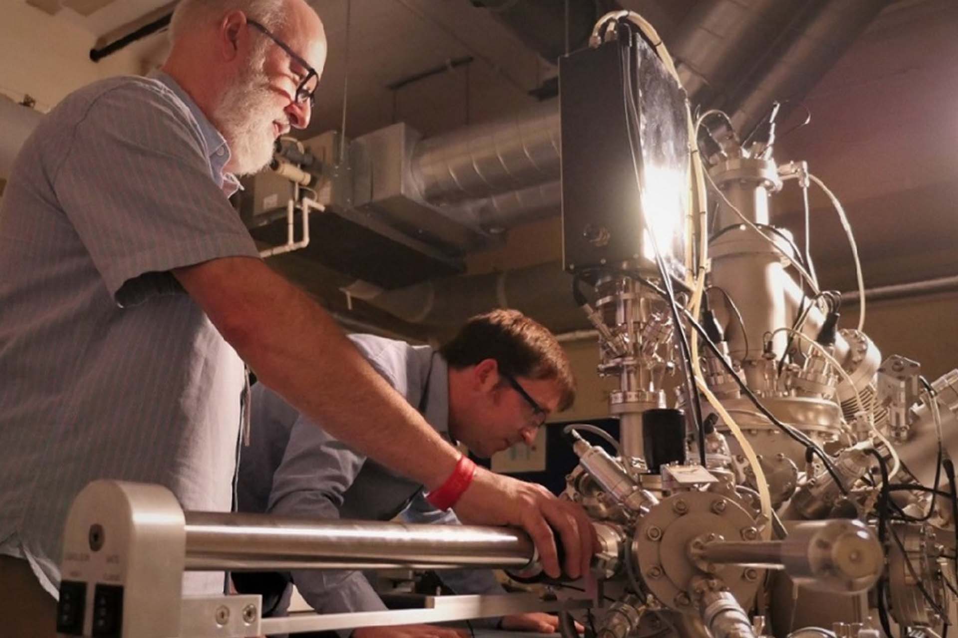 Two staff members work with our low-energy ion scattering microscope