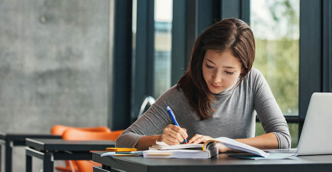 A girl writing in her study books.