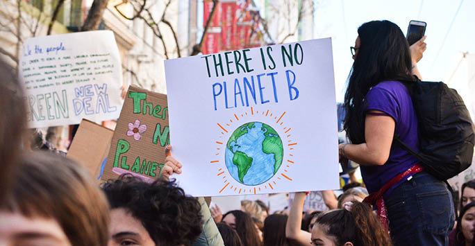 A group of people carrying a sign that reads 'There is no Planet B'.