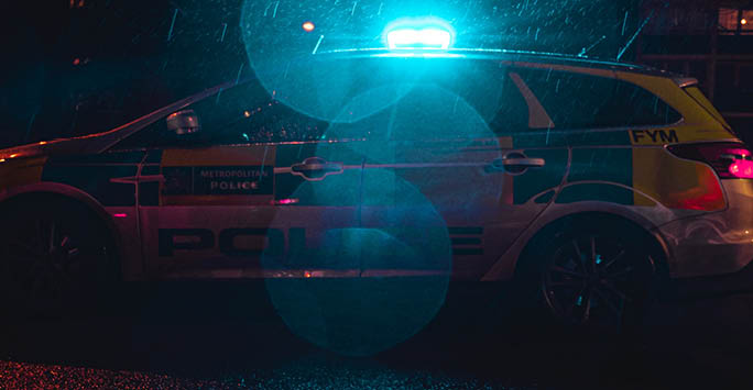 A police car at night in the rain.
