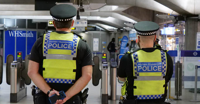 Two police men stood in the London Underground with a WHSmith in the background.