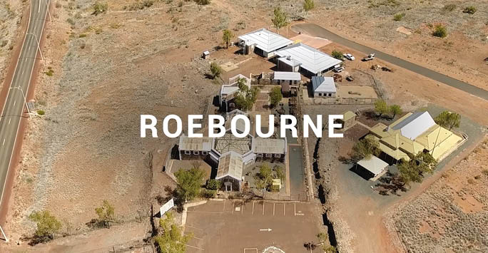 An aerial shot of Roebourne prison with text overlay that reads 'Roebourne'.