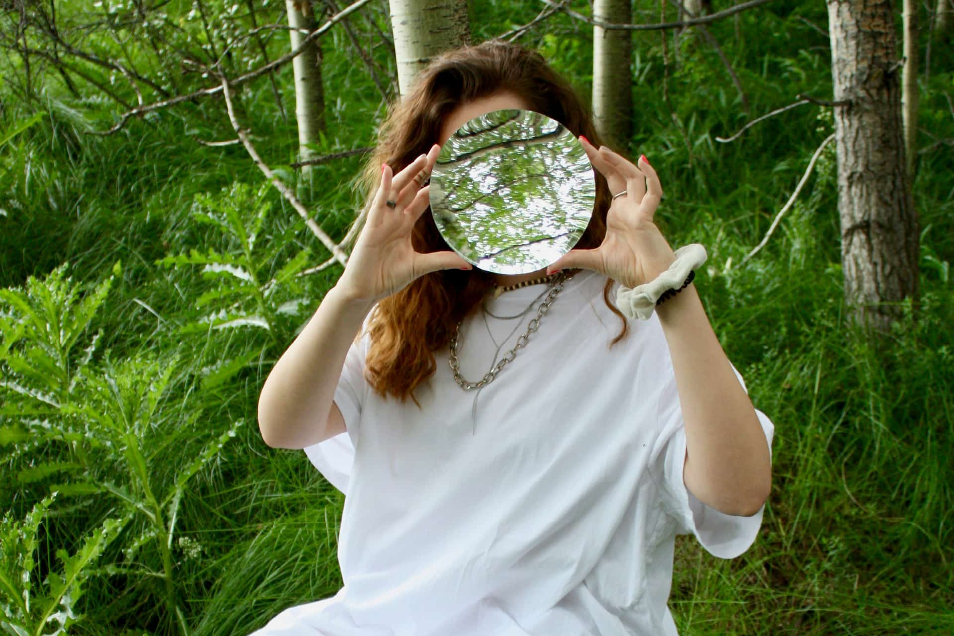 Girl holding a mirror in front of her face