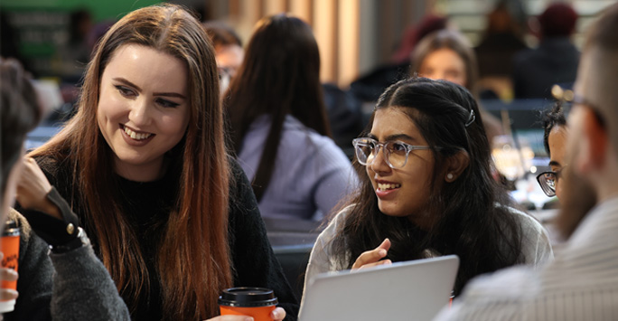 Students sat around a table together talking