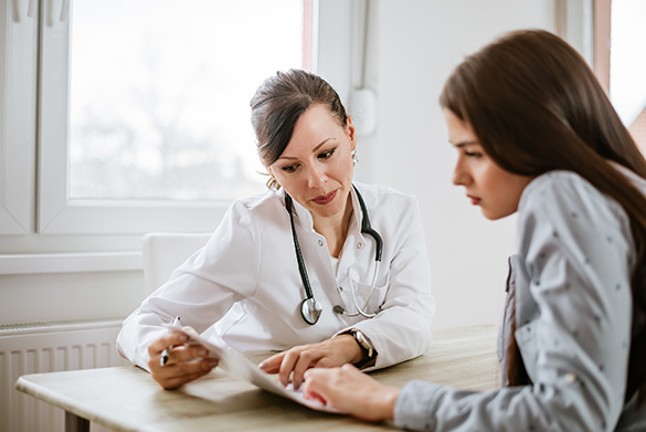A doctor and a student looking at some results on paper