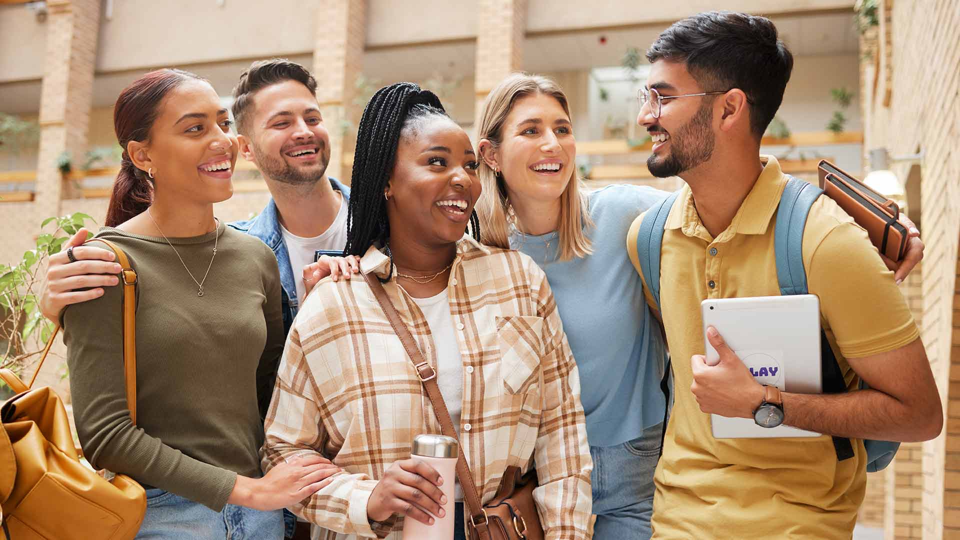 Five students chatting on a college campus.