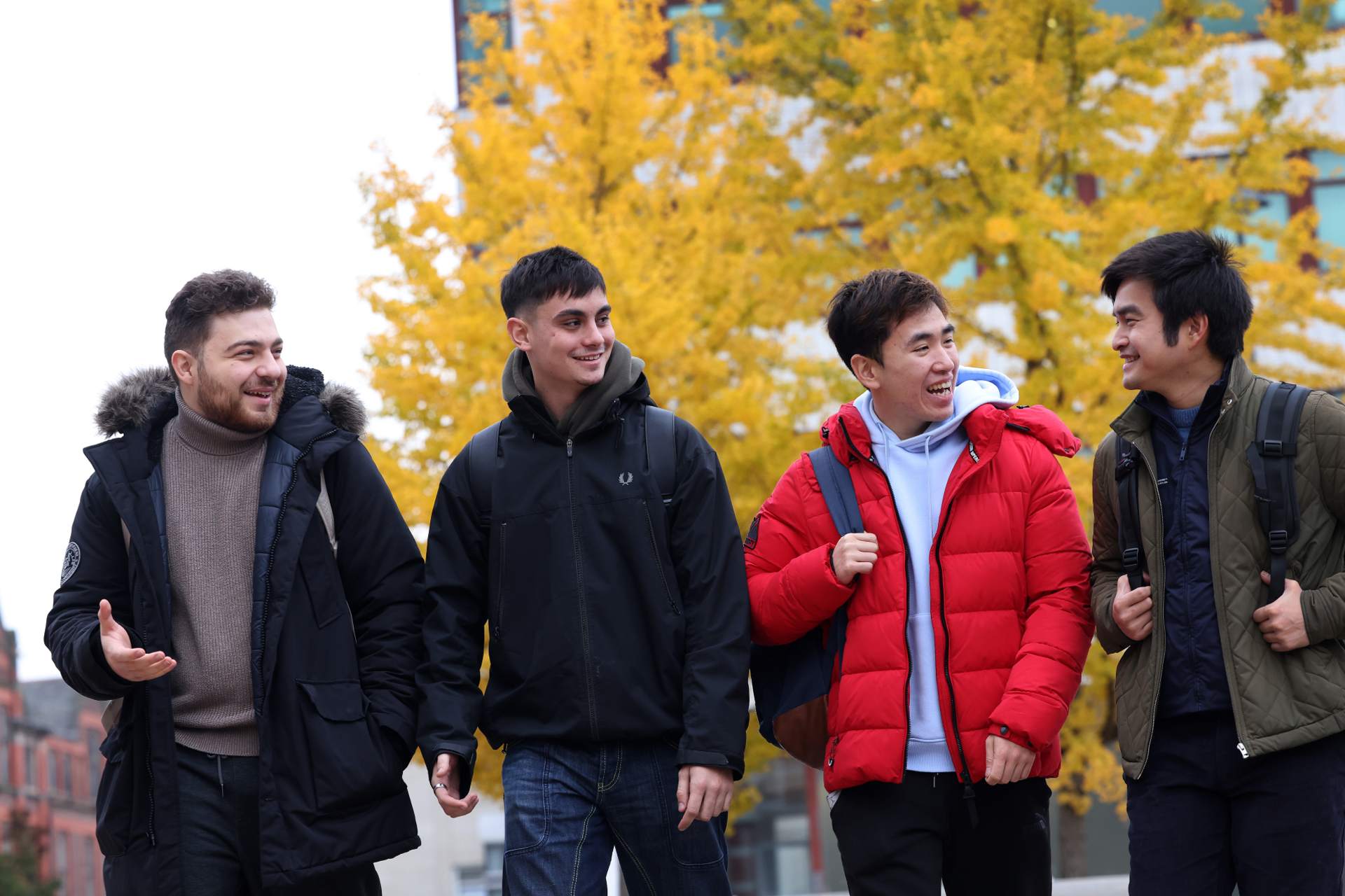 A group of students are walking across University Square, talking.