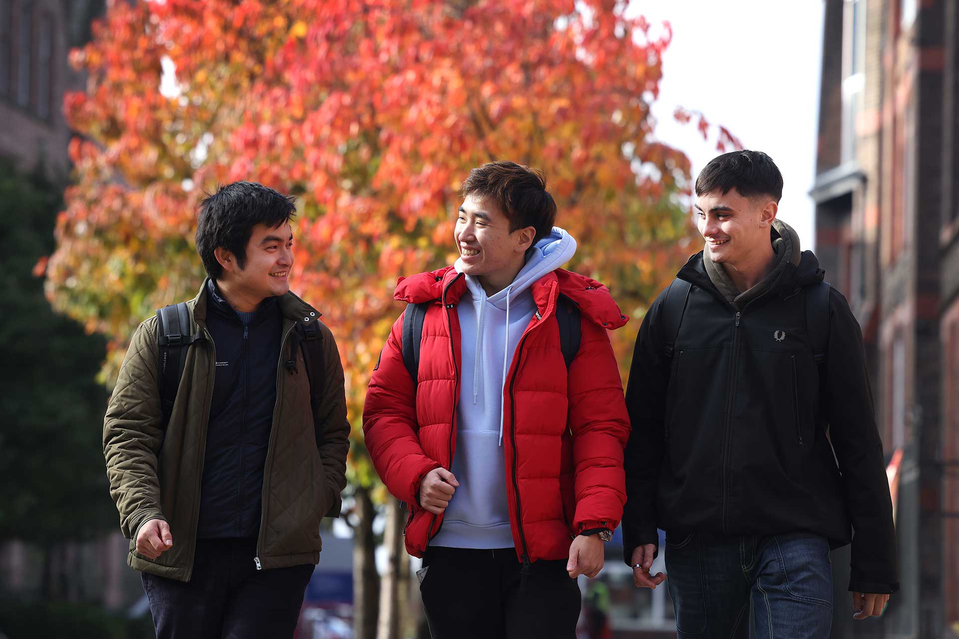 Three students walking on campus.