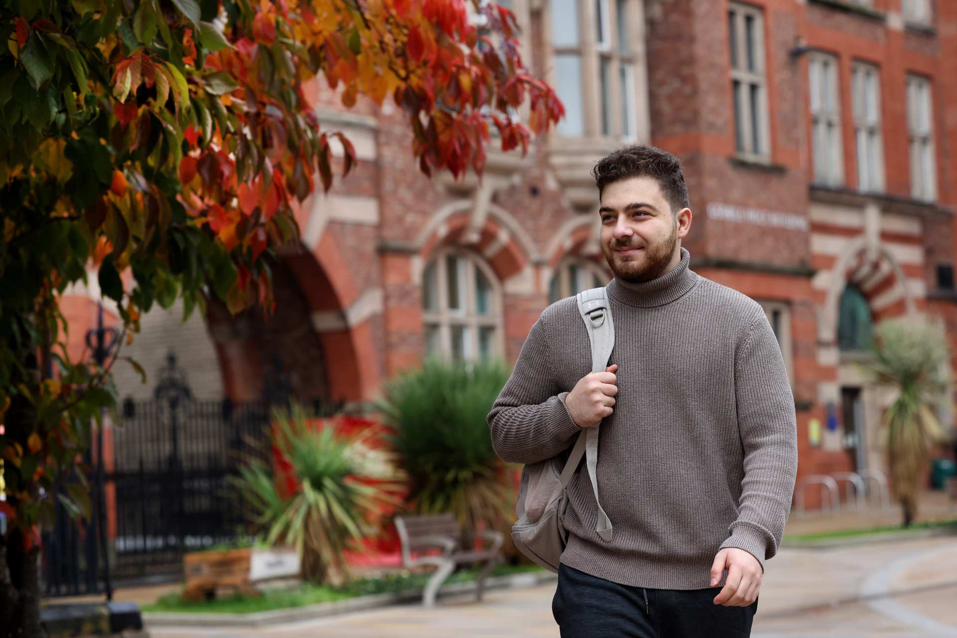 A student walking across the Quadrangle.