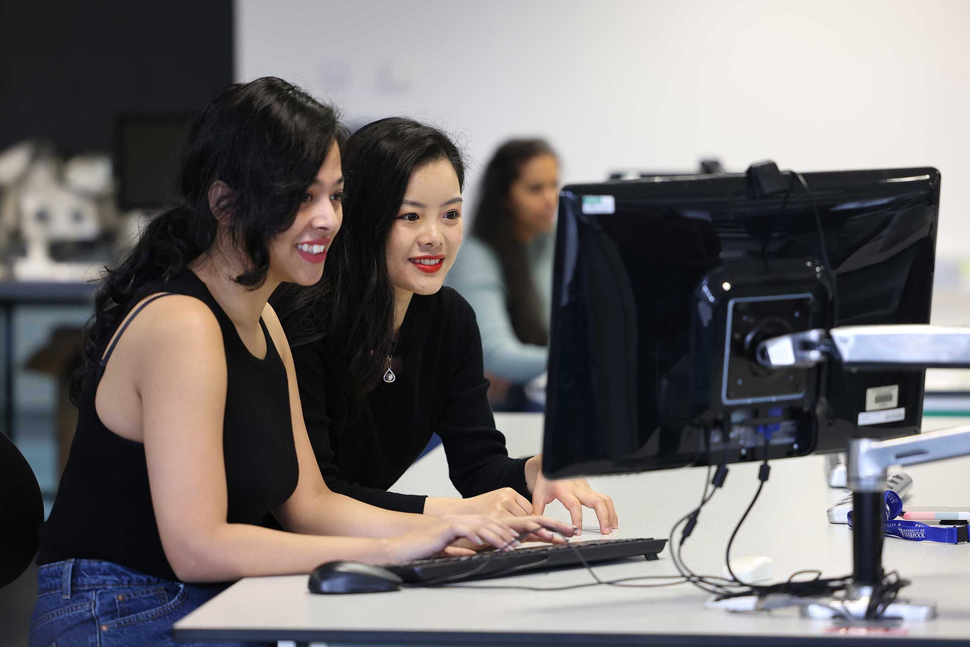 Two students working at a computer screen.
