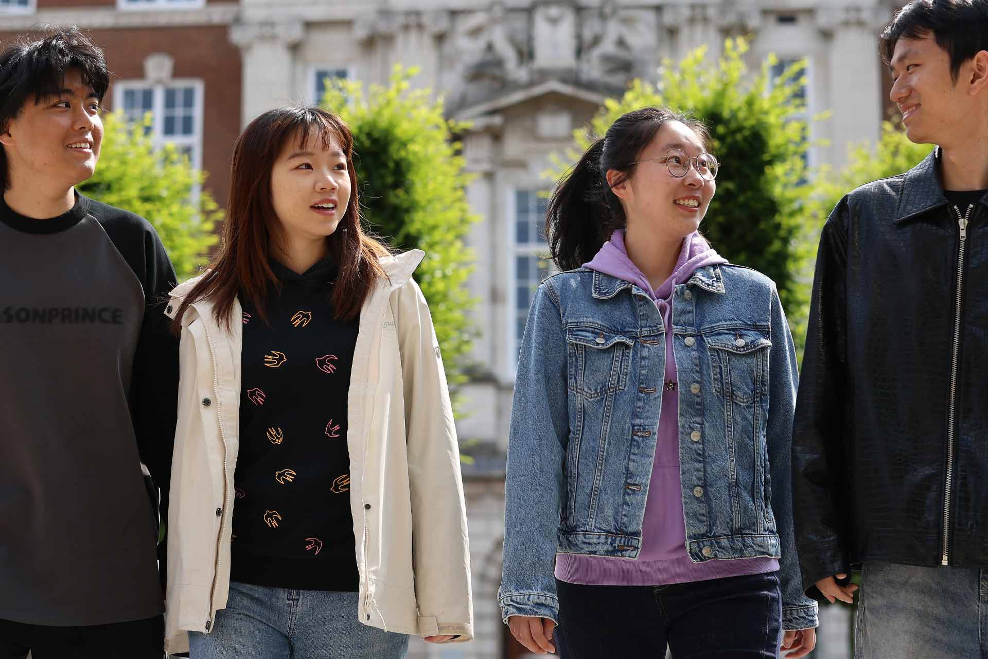 Four Chinese students walking through University Square